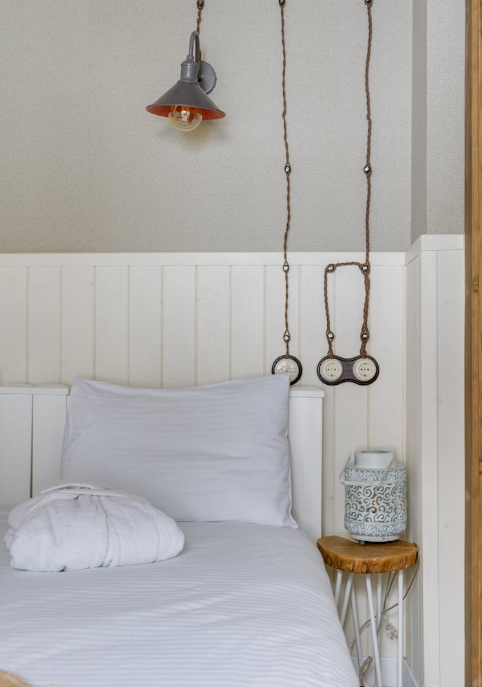 Inviting minimalist bedroom with a soft white pillow and rustic lamp.