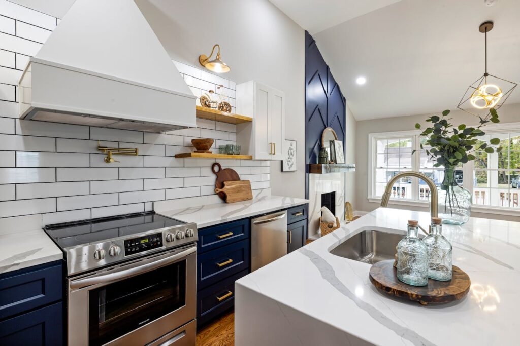 pexels photo 14495889 A modern kitchen featuring marble countertops, a stainless steel stove, and elegant blue cabinets.